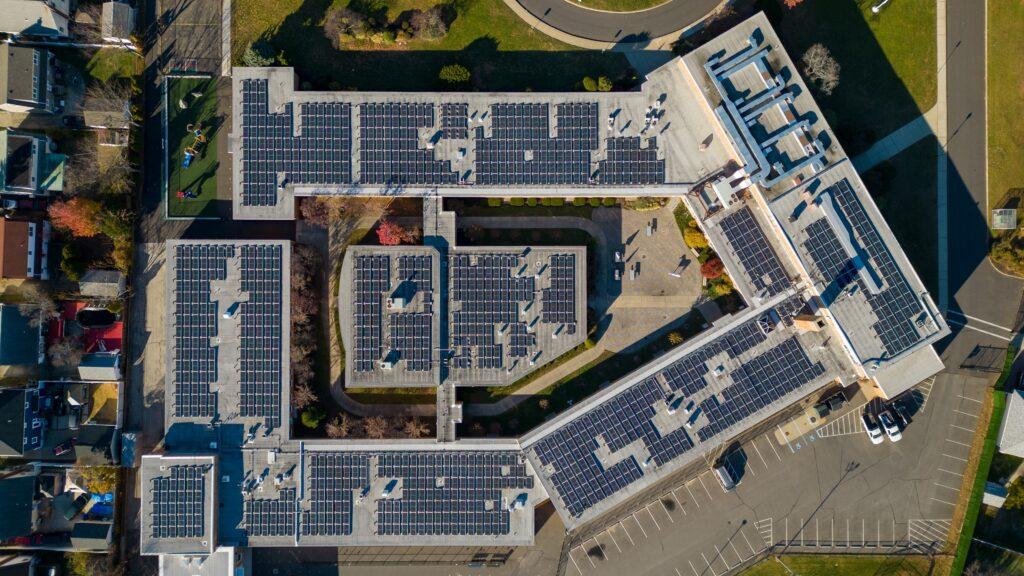 A top down shot directly over a large school building with many solar panels